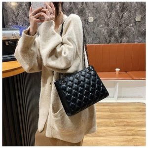 Quilted diamond pattern shoulder bag with black metal chain strap on female model