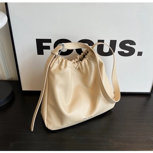 Detail view of cream drawstring soft leather shoulder bag with silver metal adjustment buckle
