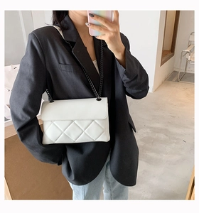 Mirror selfie showing white quilted flap bag with black chain strap on black blazer outfit