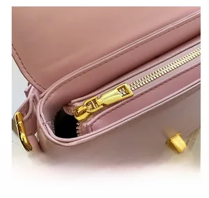 Detailed macro view of smooth golden zipper and pink leather texture on the handbag