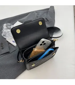 Interior view of black crossbody bag showing spacious compartments with a phone and wallet