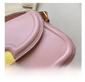 Detail of pink leather handbag with textured surface and premium gold metal lock buckle