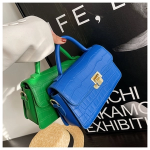 Detail of mini handbags with crocodile embossed texture and gold metallic hardware locks