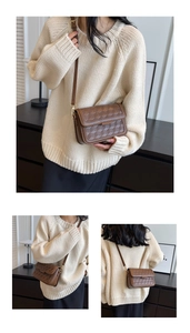 Detail view of a vintage dark brown crossbody bag with geometric embossed pattern and gold buckle