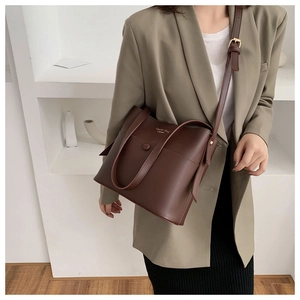 Close-up of the dark brown leather handbag featuring a golden Classic Bag logo