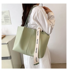 Close-up of mint green tote bag with Chia 2nd printed canvas handles on a model