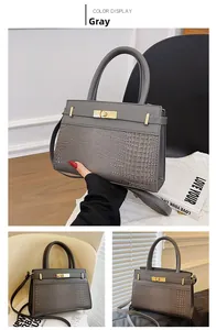 Detail of grey vintage crossbody bag featuring crocodile pattern texture and metal lock