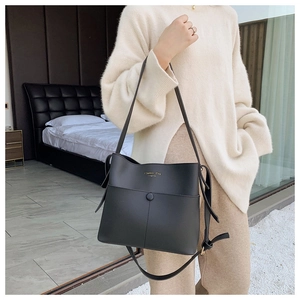 Detail showing the golden Classic Bag Original print on black matte leather shoulder bag