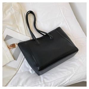 Detail of premium black lychee-textured leather on a large-capacity minimalist tote bag