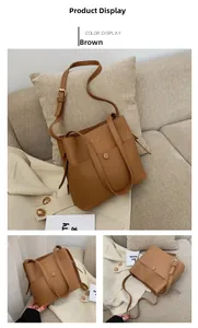 Close-up of the front pocket and golden logo lettering on a brown leather bucket bag