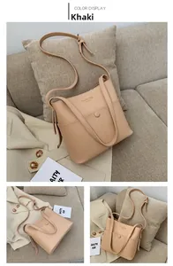 Detail of khaki bucket bag with Classic Bag print and adjustable shoulder strap on sofa