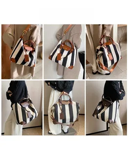 Vues détaillées d'un sac cabas à rayures noires et blanches porté à la main et à l'épaule