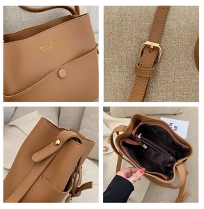 Detail view of brown leather bucket bag showing logo, strap buckle and interior lining