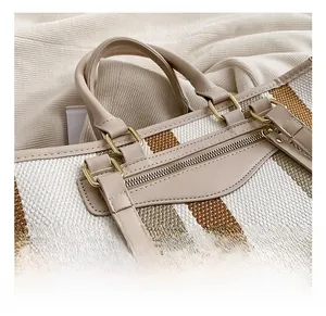 Detail van de gestreepte canvas shopper met leren handgrepen en gouden metalen rits