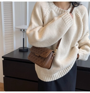 Close-up of brown vintage crossbody bag with 3D geometric embossing and metal clasp