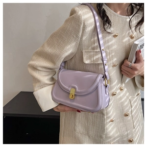 Close-up of lavender square crossbody bag with gold metallic clasp and luxury texture