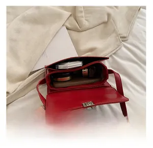 Interior view of red leather saddle bag showing capacity for phone and cosmetics