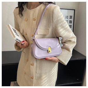 Close-up of lilac glossy shoulder bag with gold square buckle worn with tweed jacket