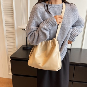 Minimalist beige soft leather bucket bag with miao & she print styled for casual wear