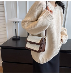 Detail of small square bag featuring white 3D geometric texture and brown leather trim