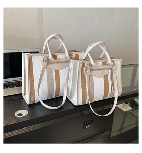 Close-up of contrast striped canvas tote bags in medium and large sizes on wood surface