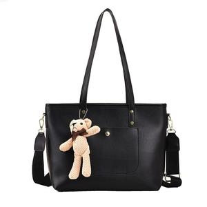 Minimalist black PU leather tote bag with gold hardware and a teddy bear pendant