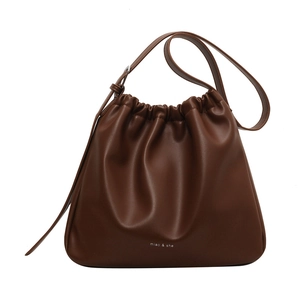 Brown soft leather drawstring bucket bag with adjustable strap on a white background
