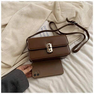 Detailed view of brown leather saddle bag featuring a unique silver metal blade lock