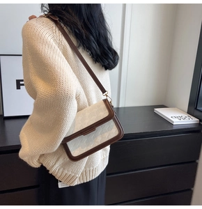 Detail shot of a vintage white checkered crossbody bag with brown leather piping and trim