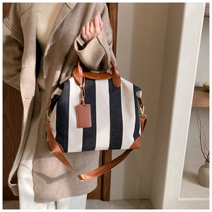Détails du sac cabas rayé en toile avec poignées en cuir et bandoulière réglable