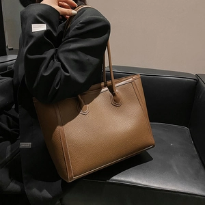 Brown large capacity tote bag with litchi texture leather shown on a model's shoulder