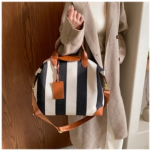 Détails du grand sac en toile à rayures noires et blanches avec finitions en cuir brun