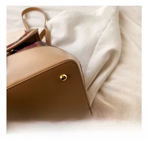 Detail showing gold metal feet and plaid fabric base of the vintage plaid handbag