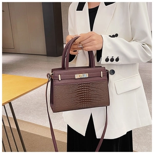 Detail of vintage crocodile embossed leather tote bag featuring golden metal buckle and strap