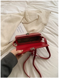 Internal view of a red faux leather saddle bag with silver twist lock and fabric lining