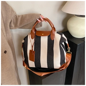Vue détaillée du sac cabas à rayures noires et blanches avec finitions en cuir marron
