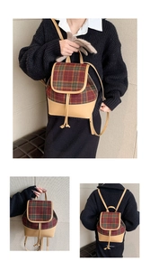 Detail view of British vintage plaid wool backpack showing top handle and drawstring straps