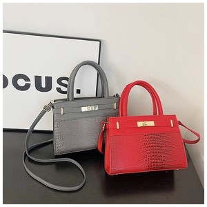 Detailed close-up of crocodile-embossed leather tote bags with gold hardware and top handles