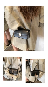 Detail of a black leather saddle bag with silver geometric clasp on a beige blazer