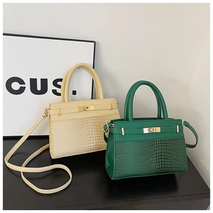 Detail showing crocodile texture and smooth PU leather of off-white and green crossbody bags