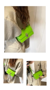 Neon green saddle shoulder bag with silver turn-lock clasp shown on a model