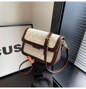 Close-up of vintage white crossbody bag with 3D geometric texture and gold buckle