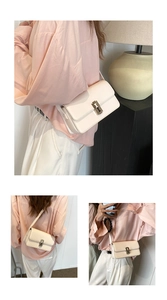 Detail view of cream saddle bag featuring T-shaped metal buckle and premium PU leather