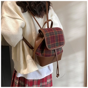 Detail of tweed check backpack with brown PU leather trim and drawstring closure