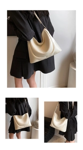 Detail of cream PU leather shoulder bag featuring gold lettering and adjustable wide strap