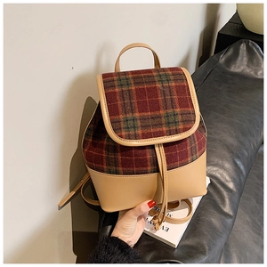 Detail of a mini plaid backpack with British tartan fabric and brown leather base