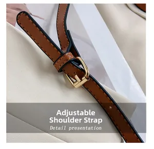 Detail of adjustable brown leather shoulder strap with a polished gold metal buckle