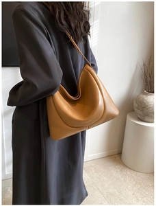 Close-up of tan leather Hobo bag with metal logo detail and spacious shoulder design