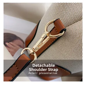 Detail of canvas bucket bag showing gold metal rings and detachable strap connection