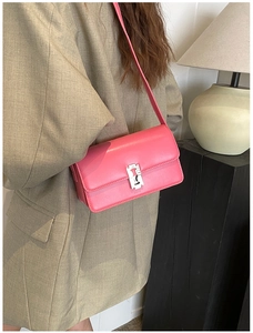 Detail of pink leather saddle bag with silver blade buckle on model in studio